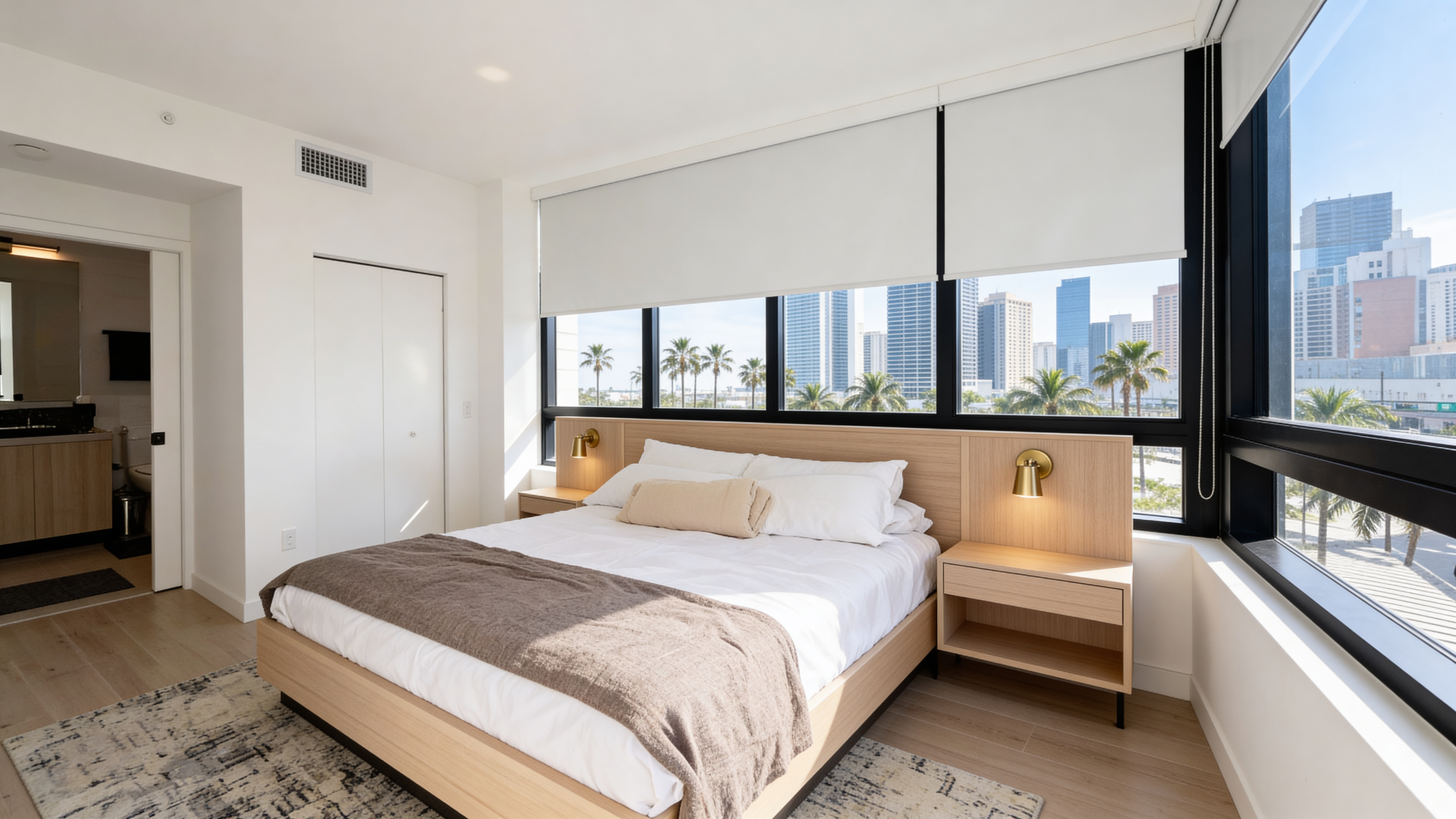 Primary bedroom — king bed, designer wall sconces, floor-to-ceiling views of Downtown Miami and Brickell