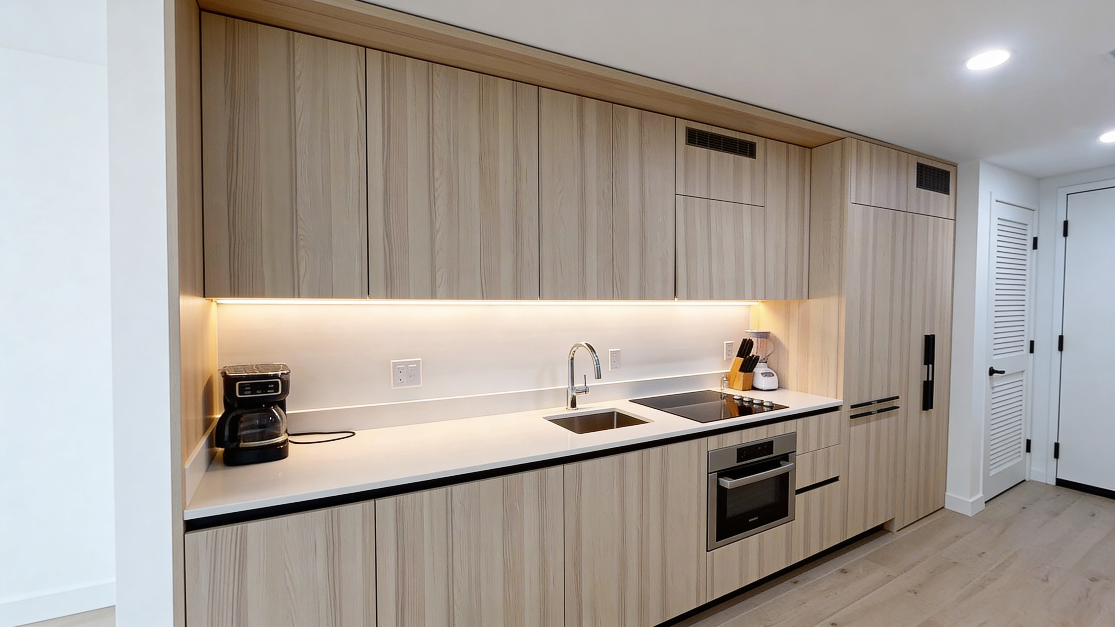 Kitchen — custom wood cabinetry, under-cabinet LED lighting, white quartz countertops