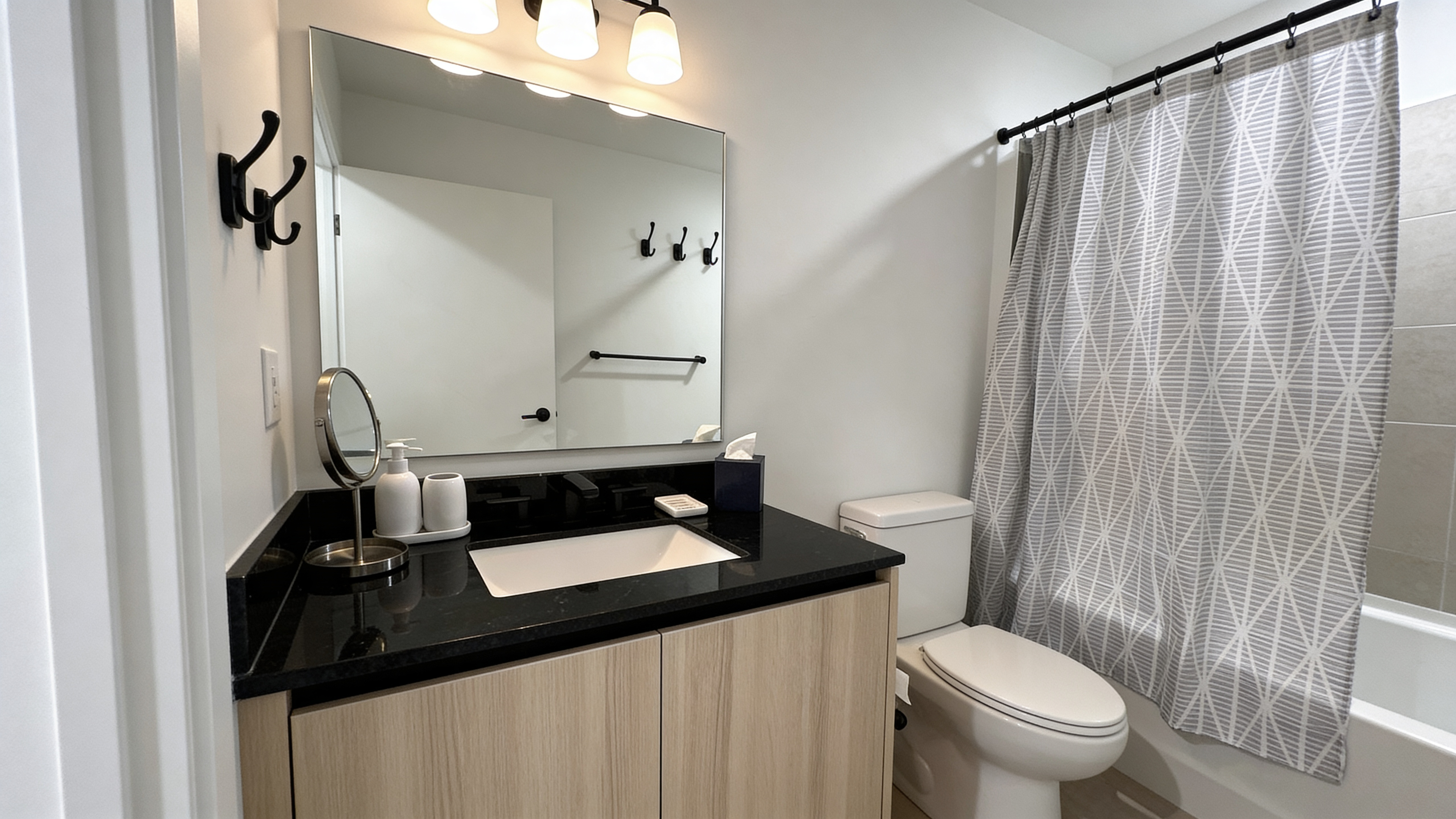 Kitchen and entry corridor — integrated appliances, wide-plank flooring throughout
